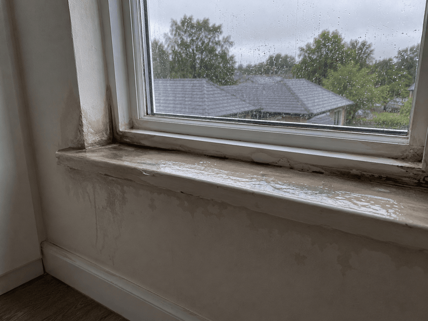Water leaking around an apartment window caused by missing head flashing and failed perimeter sealant